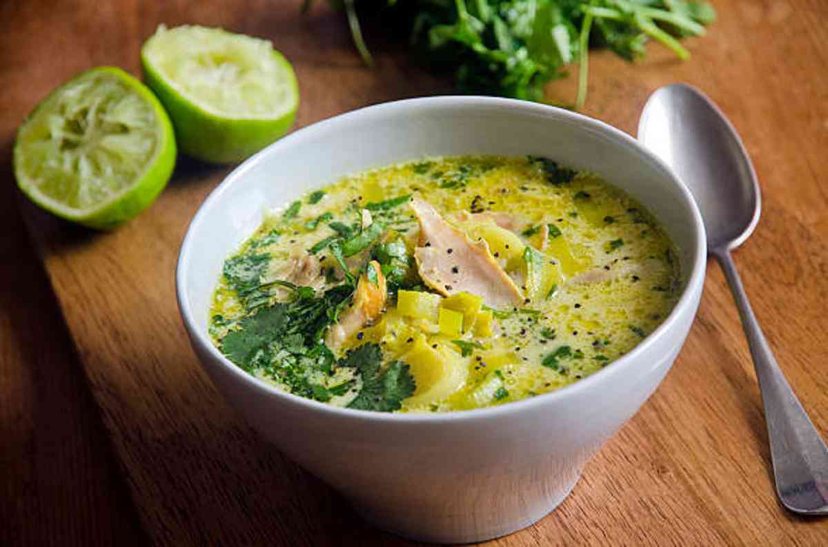 A steaming bowl of Chicken and Leek Soup with fresh herbs.
