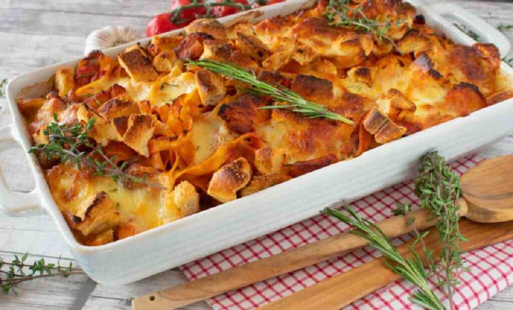 A baking dish filled with assembled hunters chicken pasta bake.
