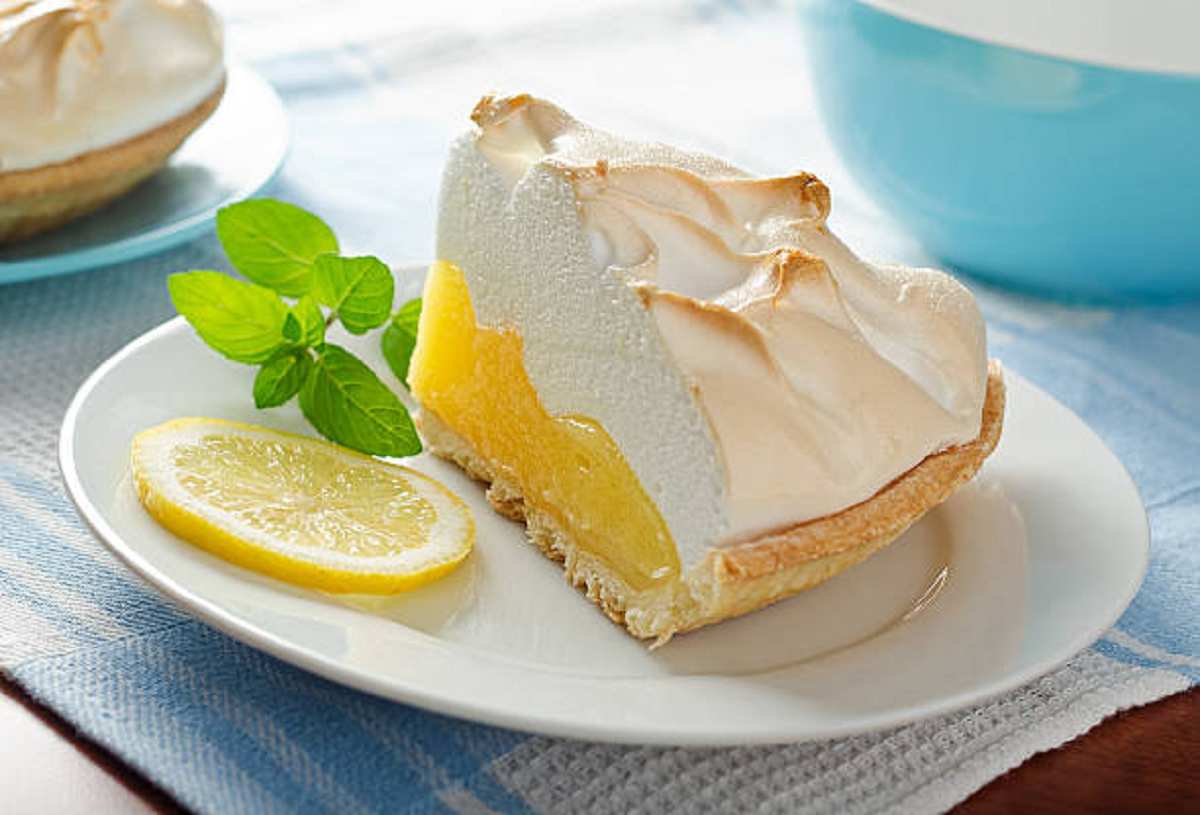 A close-up of a perfectly browned meringue topping on a lemon meringue pie.