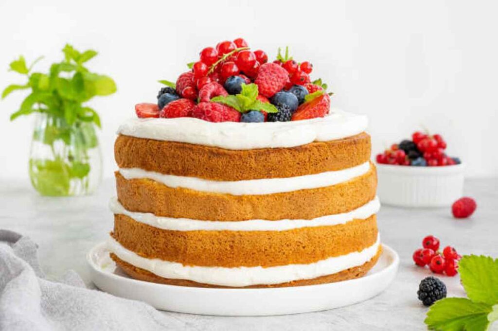 Close-up of Mary Berry's Victoria Sponge, highlighting the fluffy texture and berry toppings.